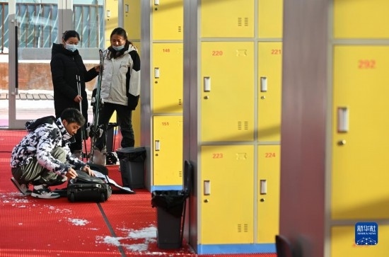 12月21日，游客在滑雪服務(wù)大廳整理滑雪裝備。