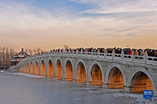 這是12月22日拍攝的頤和園十七孔橋“金光穿洞”景象。