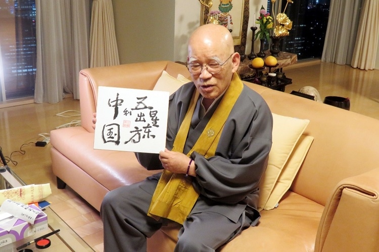 小島康譽(yù)展示自己書(shū)寫(xiě)的“五星出東方利中國(guó)”。視頻截圖