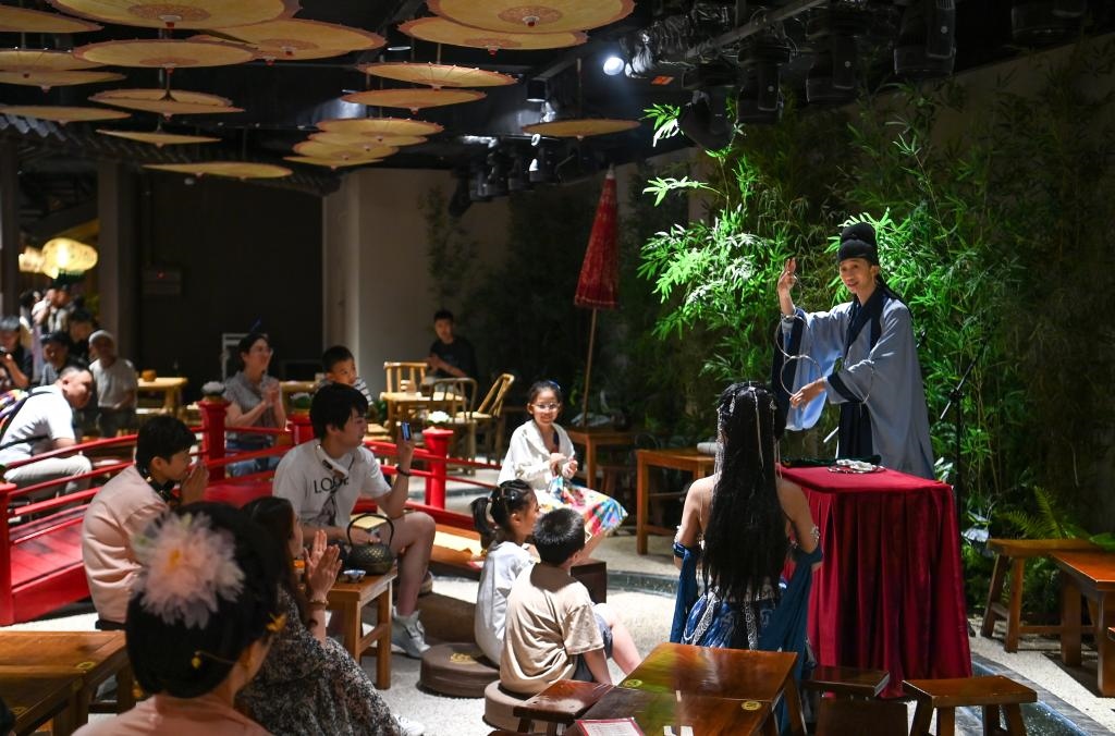 游客在長安十二時辰主題街區(qū)觀看唐風(fēng)演藝《大唐曲藝》。新華社記者鄒競一 攝