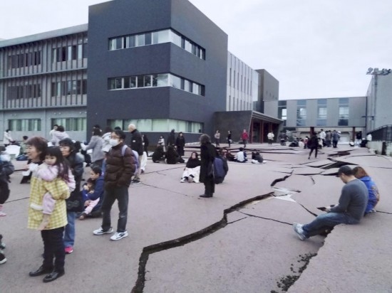  1月1日，在日本石川縣輪島市，人們站在被地震破壞的地面上。新華社/共同社