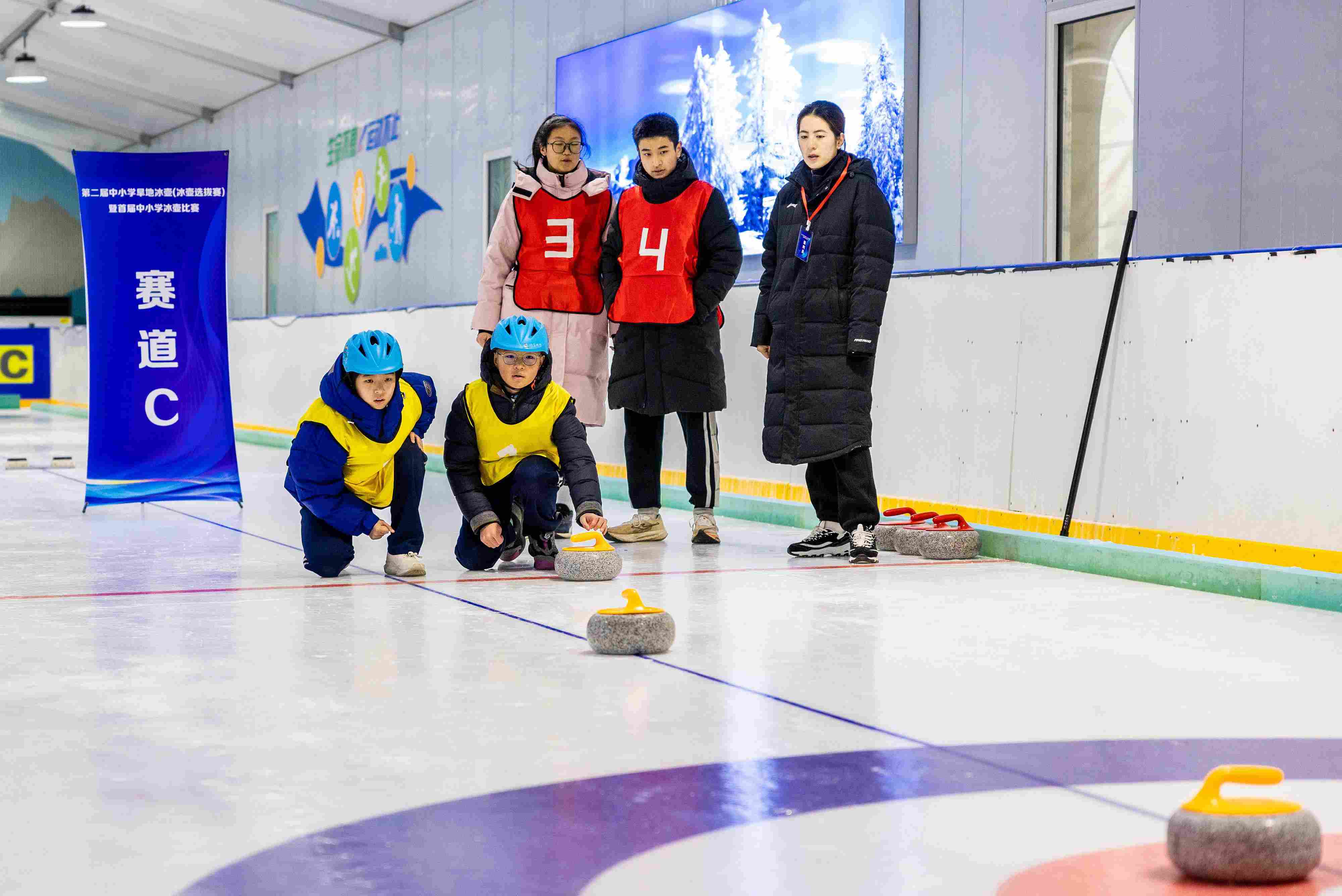 2023年12月10日，參賽選手在呼和浩特首屆中小學(xué)冰壺比賽中投擲冰壺。