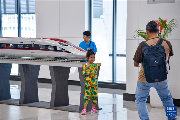 1月24日，在印度尼西亞雅加達哈利姆站候車大廳，一名小朋友和雅萬高鐵高速動車組模型合影。新華社記者 徐欽 攝