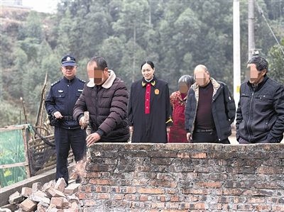 圖③：庭審結(jié)束后，在法官的見證下，陳某在院壩邊重新開鑿一條通道。