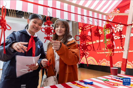 1月28日，復(fù)旦大學(xué)第二附屬學(xué)校學(xué)生（左）為美國馬斯卡廷中學(xué)學(xué)生（右）介紹中國結(jié)。 新華社記者 王翔 攝