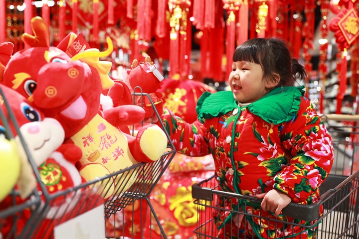 1月23日，在貴州省黔東南苗族侗族自治州岑鞏縣一家超市，小朋友在家人的帶領(lǐng)下選購(gòu)龍年毛絨玩具。新華社發(fā)（唐鵬攝）