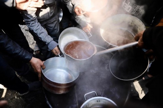 2月27日，在加沙地帶北部的杰巴利耶難民營，人們領(lǐng)取食物。新華社發(fā)（穆罕默德·阿里攝）