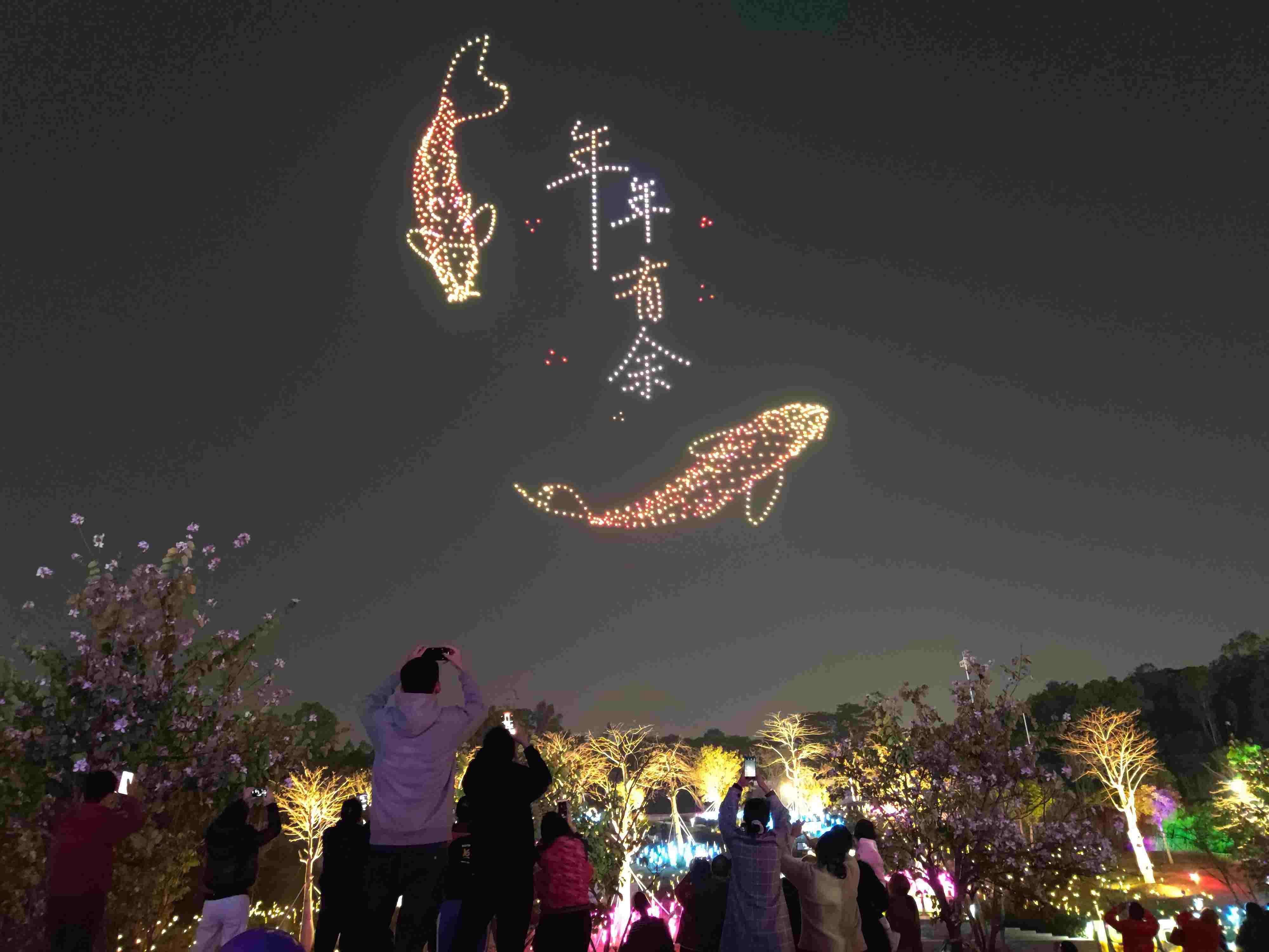 △ 2024年2月10日，深圳北站中心公園，春節(jié)主題無(wú)人機(jī)燈光秀引來(lái)眾多游客駐足觀看。