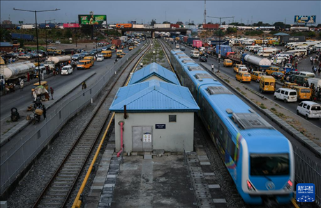 3月4日，在尼日利亞拉各斯，一列輕軌藍(lán)線列車(chē)行駛至公路交通擁堵路段附近。新華社記者 韓旭 攝