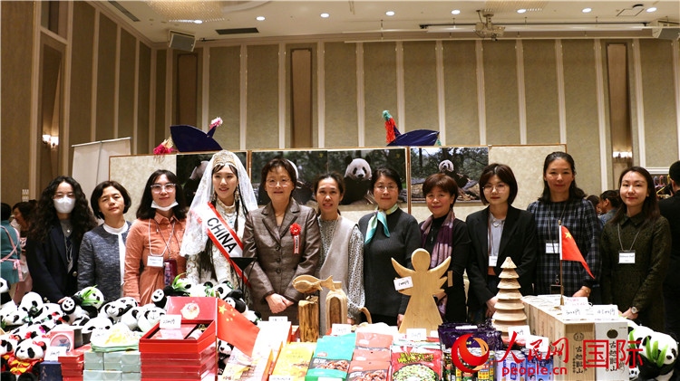 中國駐日本大使吳江浩夫人丁玥（左五）與使館人員在展位前合影留念。人民網(wǎng) 許可攝