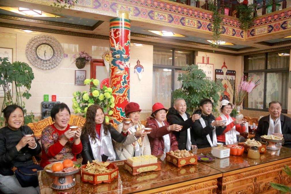 游客們?nèi)胱∶袼藓?，舉杯共飲酥油茶。新華社記者 邱星翔 攝