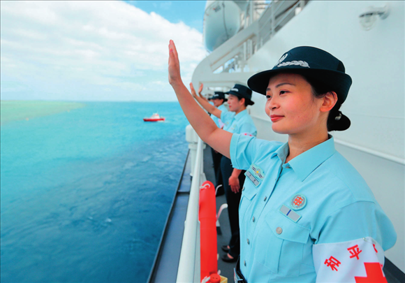中國(guó)海軍“和平方舟”號(hào)醫(yī)院船結(jié)束訪問(wèn)湯加時(shí)，任務(wù)官兵中的文職人員向歡送人群揮手告別（2023年8月4日攝）。徐巍攝/本刊