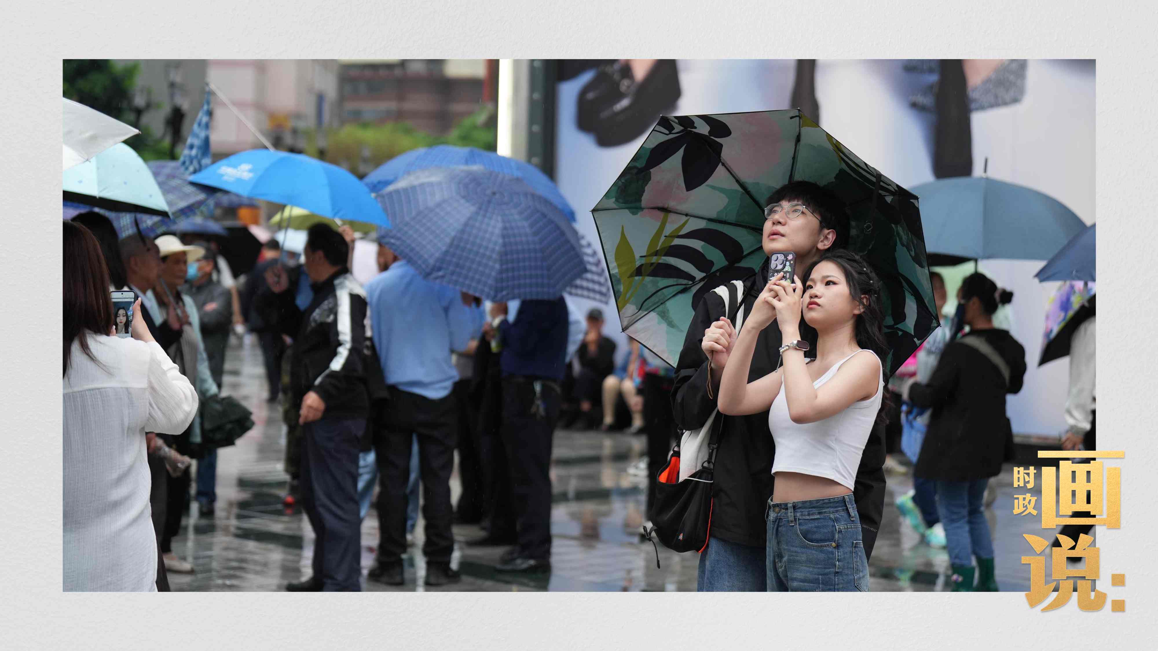 △細(xì)雨中的解放碑步行街，騎在父親肩膀的小女孩好奇張望。