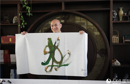 老撾駐華大使館三秘明君參加《五百筆·瀾湄合作》集體藝術(shù)創(chuàng)作。人民網(wǎng)王婧攝。
