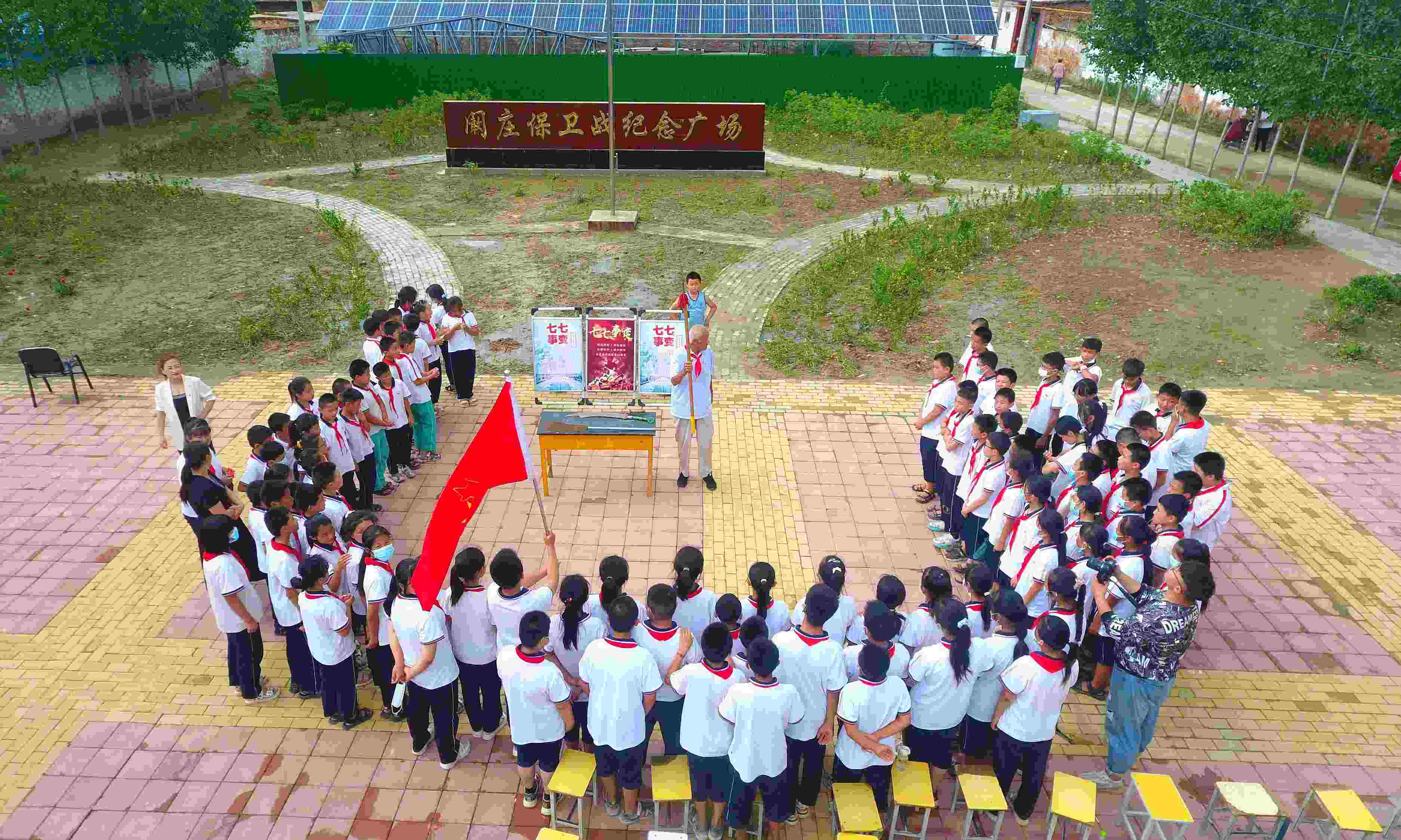 2022年7月6日，山東省聊城市，在茌平區(qū)菜屯鎮(zhèn)闞莊村的闞莊保衛(wèi)戰(zhàn)紀(jì)念廣場(chǎng)，闞莊保衛(wèi)戰(zhàn)親歷者王光木老人為小學(xué)生們講述抗戰(zhàn)故事，展示大刀、長(zhǎng)矛。