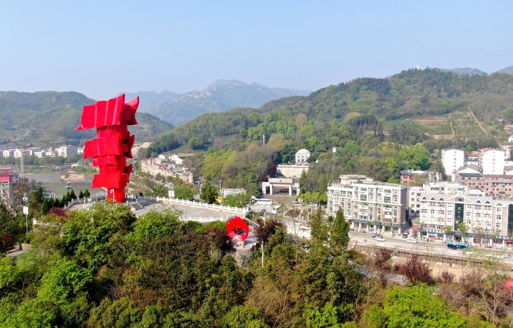 這是2021年4月9日拍攝的鄂豫皖蘇區(qū)首府革命博物館附近的英雄山上的“紅旗飄飄”主題雕塑（無人機照片）。新華社發(fā)