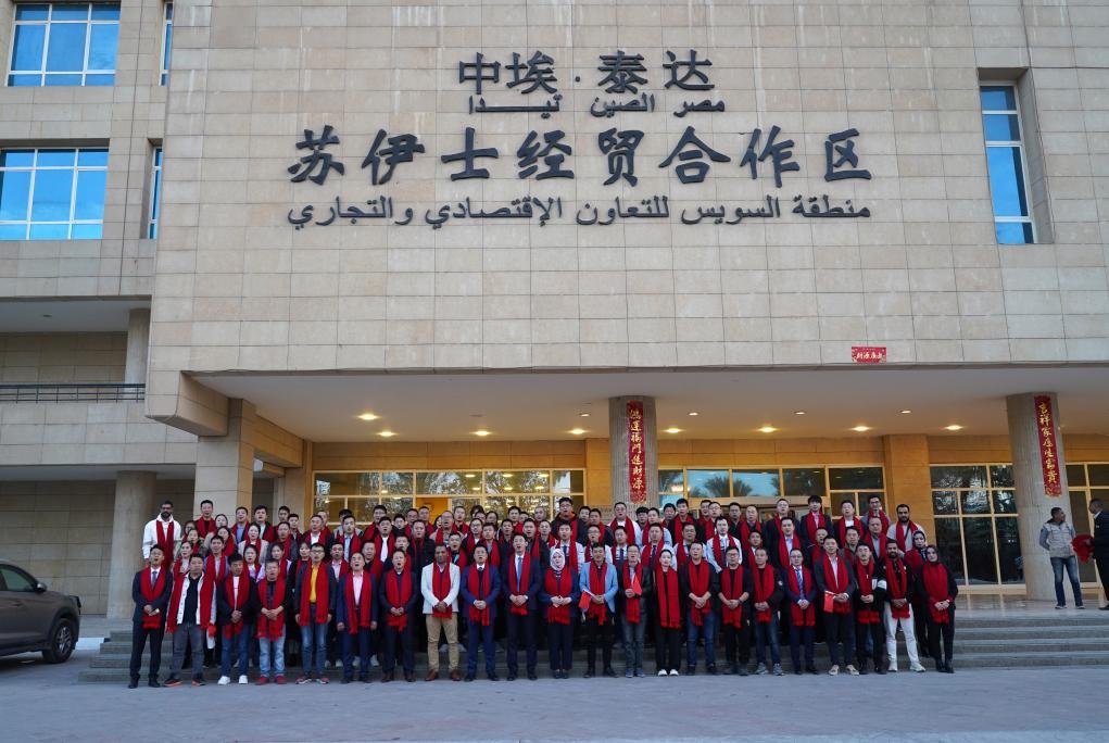 2024年2月11日，在位于埃及蘇伊士省的中?！ぬ┻_蘇伊士經(jīng)貿(mào)合作區(qū)，中埃員工在合作區(qū)辦公大樓前合影拜年。新華社發(fā)（泰達合作區(qū)供圖）