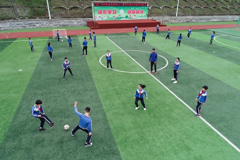 陜西安康平利縣老縣鎮(zhèn)中心小學的學生在操場上踢球。