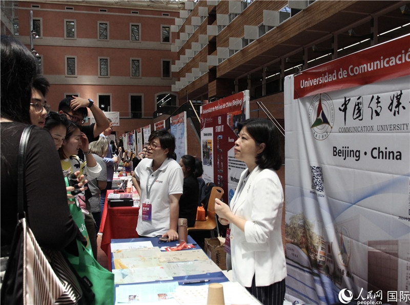旅西華人華僑在展臺前咨詢。人民網(wǎng)記者 許海林?jǐn)z