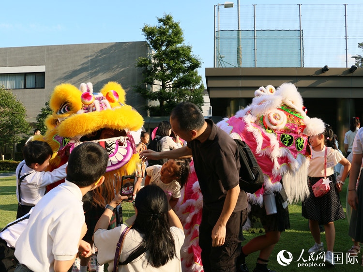 孩子們好奇地圍觀舞獅。人民網(wǎng) 許可攝