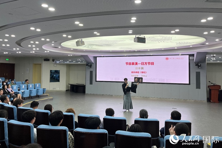日本大學(xué)生介紹能樂知識(shí)。人民網(wǎng)記者 陳思攝