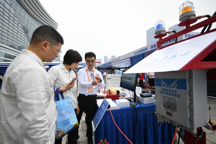 6月16日，在全國“安全宣傳咨詢?nèi)铡敝鲌龌顒由?，四川省安全科學(xué)技術(shù)研究院工作人員（右一）向參觀者介紹“有限空間作業(yè)實時風(fēng)險管控系統(tǒng)”。新華社記者胥冰潔攝