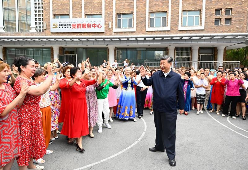 2022年7月13日，習(xí)近平總書(shū)記在新疆烏魯木齊市天山區(qū)固原巷社區(qū)考察時(shí)，向各族群眾揮手致意。