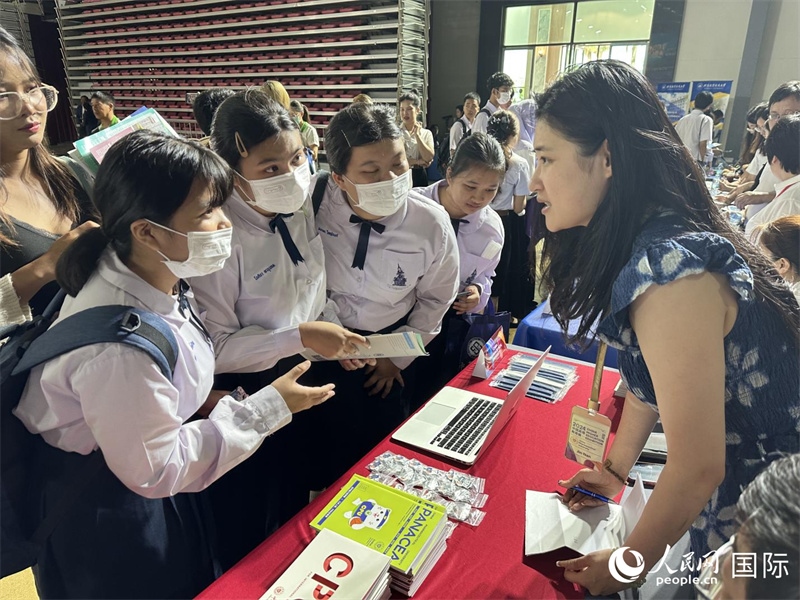 來自泰國的學(xué)生、家長在教育展臺(tái)前咨詢。人民網(wǎng)記者 簡承淵攝