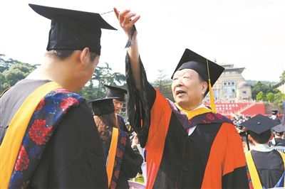 2017年6月22日，李德仁（右一）參加武漢大學(xué)畢業(yè)典禮并為畢業(yè)生撥穗。
