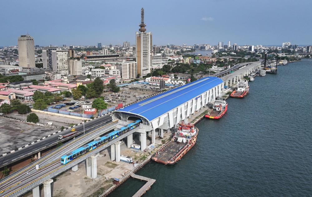 2024年3月2日，在尼日利亞拉各斯，一列輕軌藍(lán)線列車(chē)駛?cè)氪a頭站（無(wú)人機(jī)照片）。拉各斯輕軌藍(lán)線是西非地區(qū)首條由中國(guó)企業(yè)自主設(shè)計(jì)、建造、施工、運(yùn)營(yíng)的電氣化城市軌道交通項(xiàng)目。新華社記者 韓旭 攝
