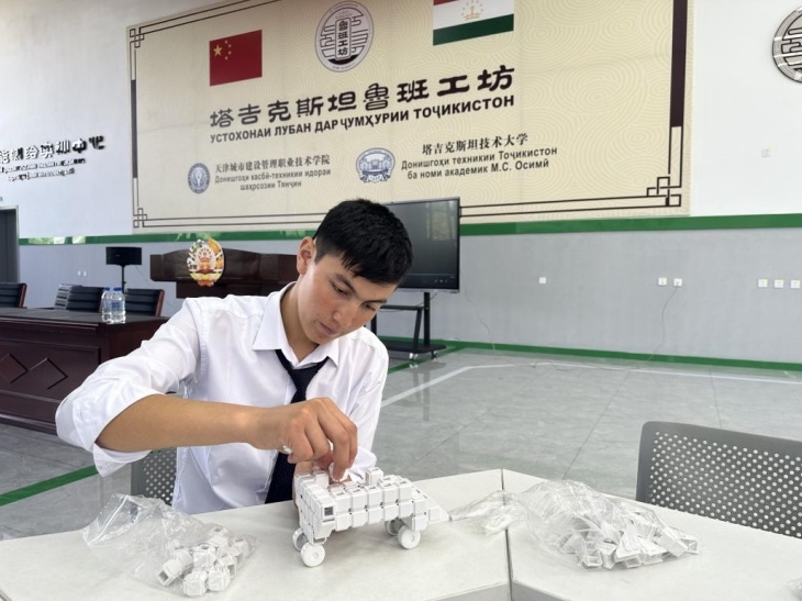 在塔吉克斯坦魯班工坊內(nèi)，學員正在操作能力源創(chuàng)新套件。本報記者 屈佩 攝