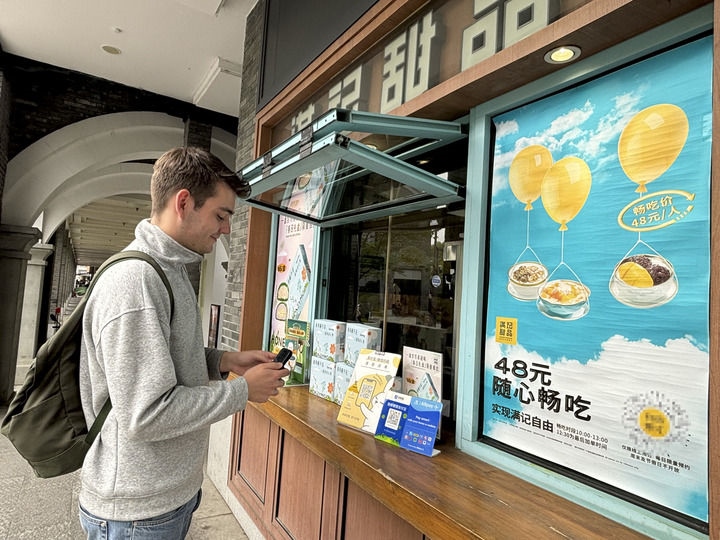 來自德國的留學生理查德在杭州西湖邊一家商鋪使用支付寶掃碼支付（2024年4月11日攝）。新華社發(fā)