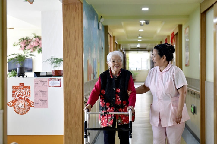 2024年5月25日，在山東省日照市東港區(qū)石臼街道日照幸福護(hù)理院，工作人員在陪護(hù)老人。新華社記者 郭緒雷 攝