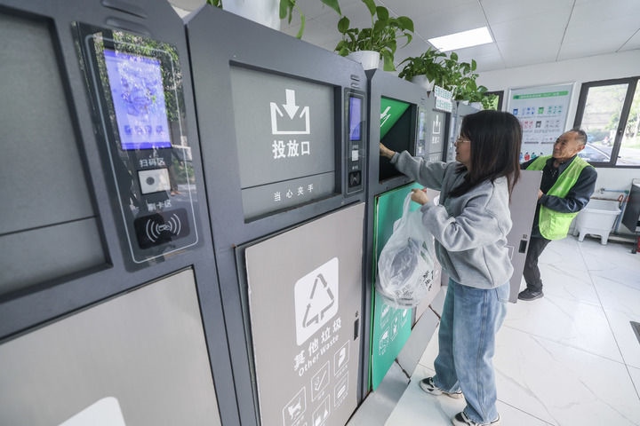 2024年4月10日，在浙江省湖州市吳興區(qū)飛英街道新華府小區(qū)內(nèi)，居民在垃圾分類(lèi)智能系統(tǒng)的指導(dǎo)下進(jìn)行垃圾分類(lèi)投放，居民的投放情況將實(shí)時(shí)匯總到智慧服務(wù)平臺(tái)，會(huì)有相應(yīng)的積分獎(jiǎng)勵(lì)。新華社記者 徐昱 攝