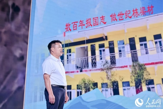張玉滾分享用一根扁擔(dān)送孩子們走出大山的故事。人民網(wǎng)攝