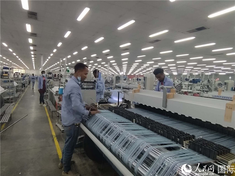 無錫金茂埃塞面料廠車間內(nèi)，當?shù)毓と苏谝唤z不茍地作業(yè)。人民網(wǎng)記者 黃培昭攝