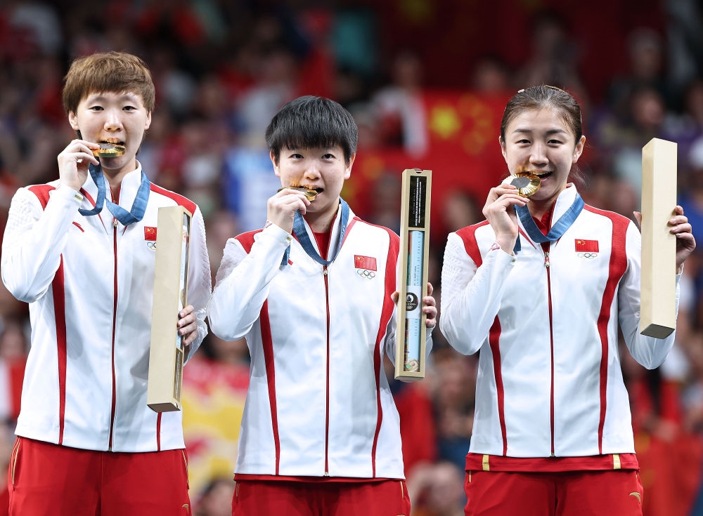 冠軍中國隊選手王曼昱、孫穎莎、陳夢（從左至右）在巴黎奧運會乒乓球女子團(tuán)體頒獎儀式上（2024年8月10日攝）。新華社記者 王東震 攝