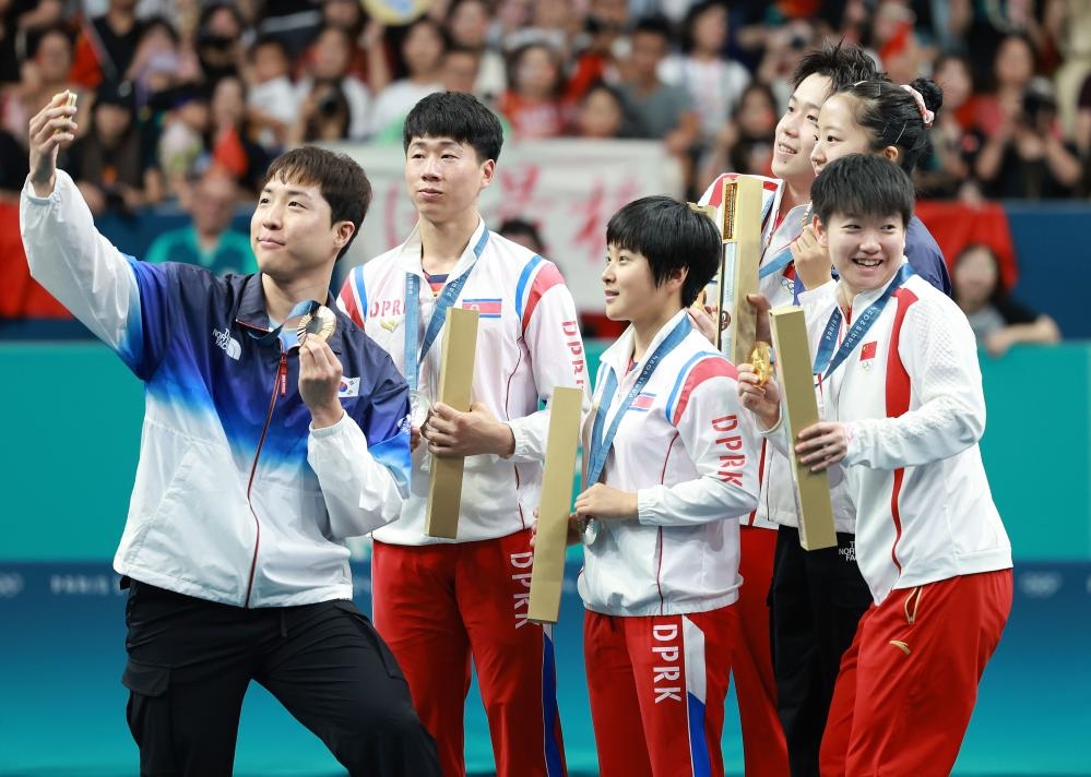 冠軍中國組合王楚欽（右三）/孫穎莎（右一）、亞軍朝鮮組合李正植（左二）/金琴英（左三）、季軍韓國組合林鐘勛（左一）/申裕斌在巴黎奧運會乒乓球混雙頒獎儀式上合影（2024年7月30日攝）。新華社記者 劉續(xù) 攝