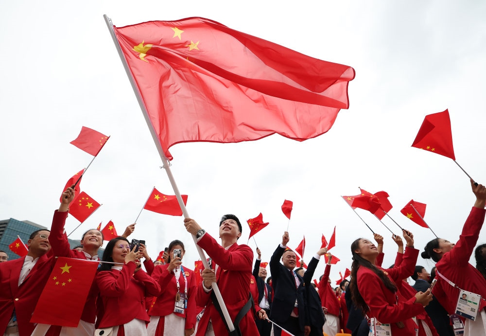 中國體育代表團(tuán)旗手、乒乓球選手馬龍在第33屆夏季奧林匹克運動會開幕式前揮舞國旗（2024年7月26日攝）。新華社記者 曹燦 攝