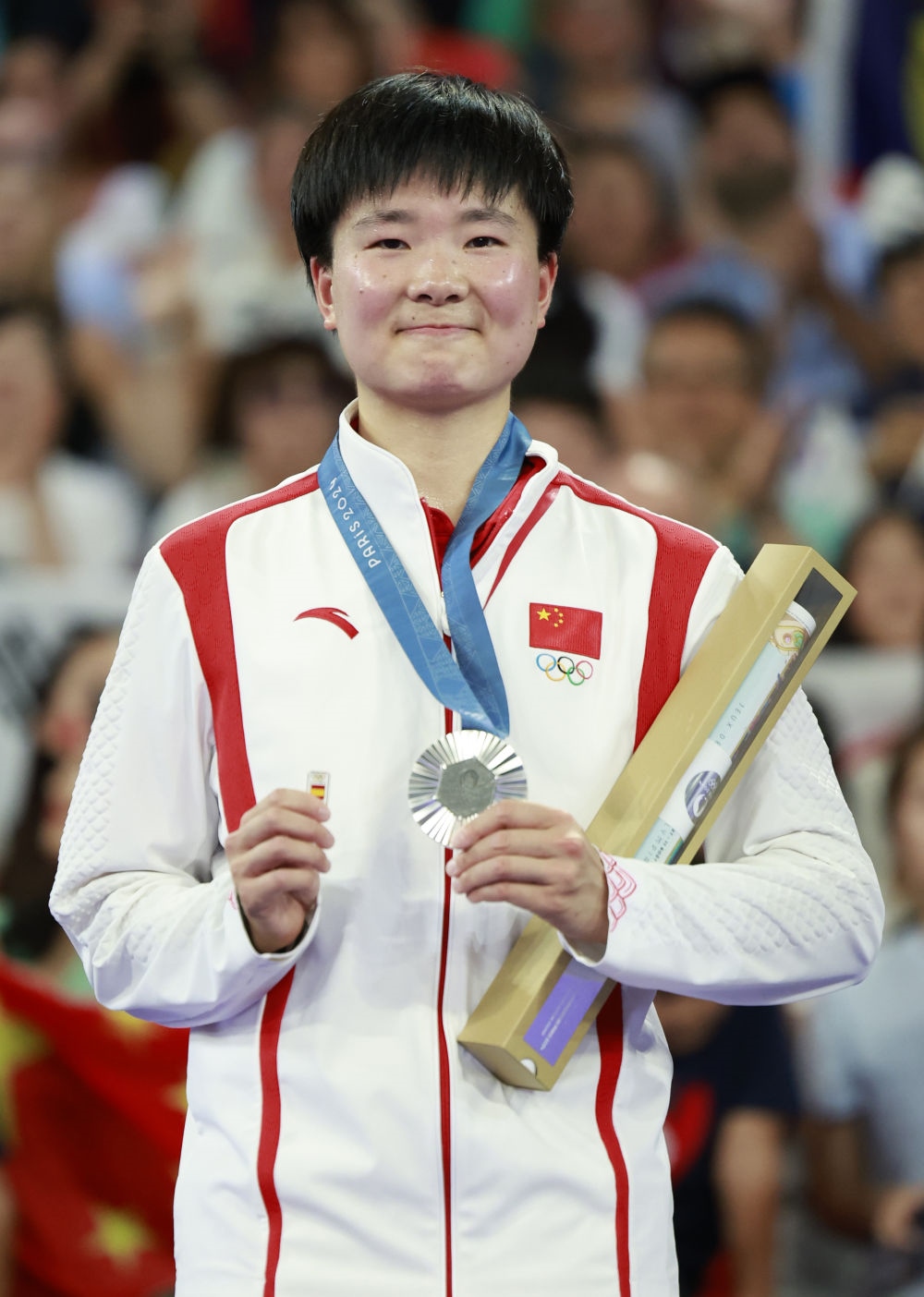 巴黎奧運會羽毛球女子單打亞軍、中國選手何冰嬌在頒獎儀式上一手握著銀牌，一手握著西班牙奧委會徽章（2024年8月5日攝）。新華社記者 任正來 攝