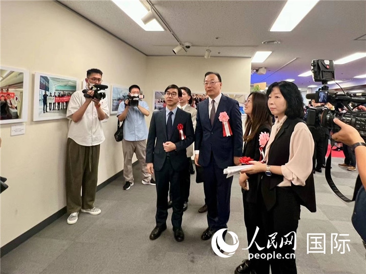 中國國際航空日韓地區(qū)支社支社長馮力為中國駐日本大使館臨時代辦施泳等嘉賓介紹展出圖片。人民網(wǎng) 許可攝