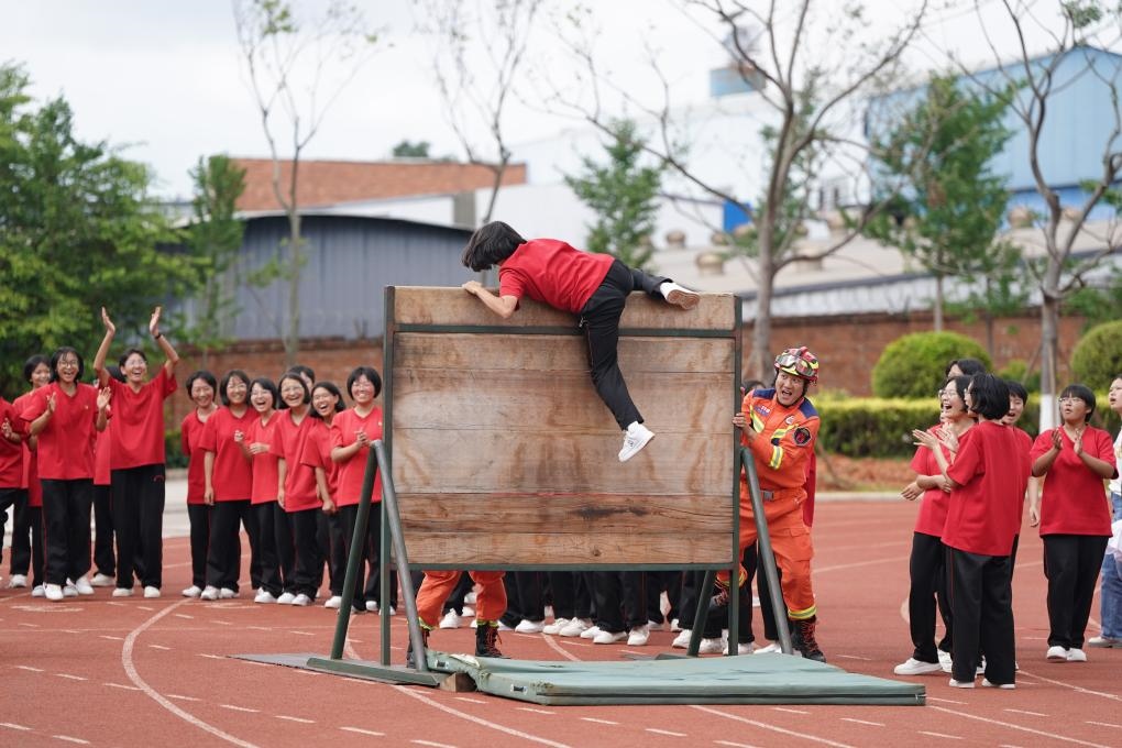 云南麗江華坪女子高級中學(xué)學(xué)生在體驗(yàn)翻越障礙板。新華社記者陳欣波 攝