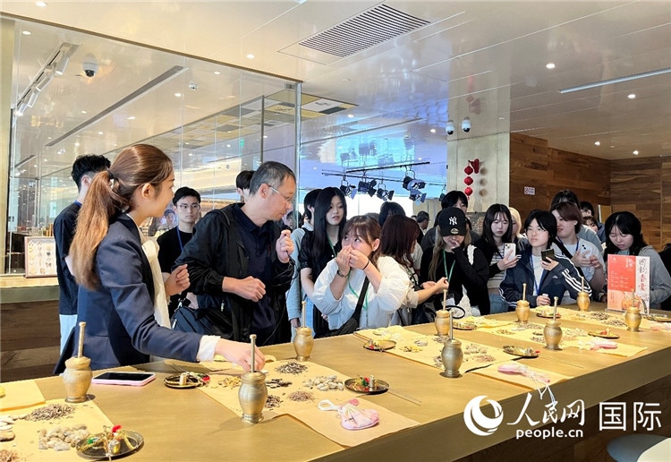 1. 日中友好協(xié)會青年代表團一行學(xué)習(xí)中醫(yī)香囊制作工序。（人民網(wǎng)記者陳思 攝）