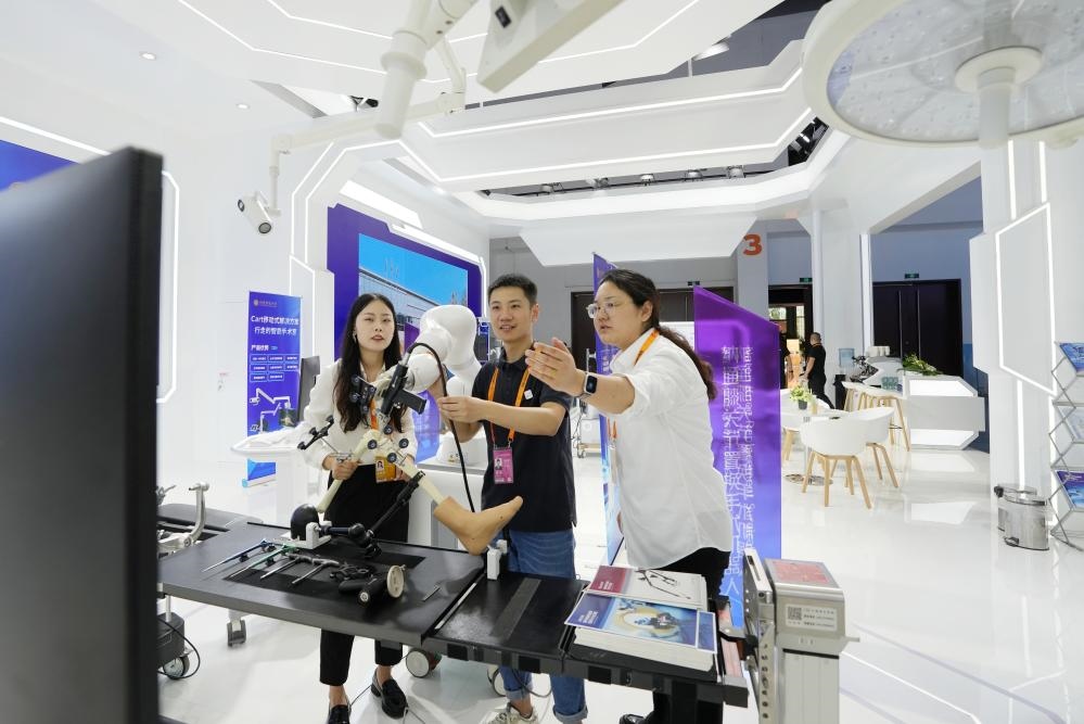 9月11日，一位媒體記者（中）在2024年服貿(mào)會國家會議中心會場體驗(yàn)北京納通科技集團(tuán)有限公司的膝關(guān)節(jié)置換手術(shù)機(jī)器人。新華社記者鞠煥宗 攝