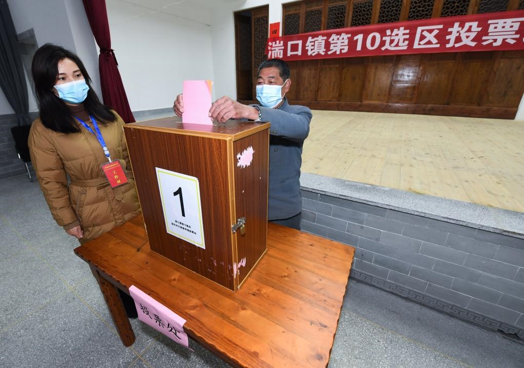 2021年12月14日，在浙江省杭州市臨安區(qū)湍口鎮(zhèn)迎豐村的基層投票點，村民在參加投票，村級監(jiān)察聯(lián)絡(luò)員監(jiān)票。新華社記者 徐昱 攝