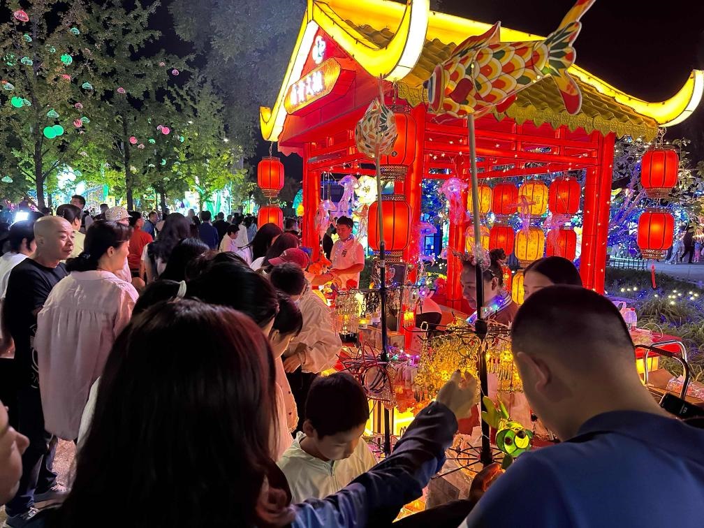 市民游客在2024年北京中秋國(guó)慶彩燈游園會(huì)上選購(gòu)特色文創(chuàng)商品。新華社記者楊淑君 攝