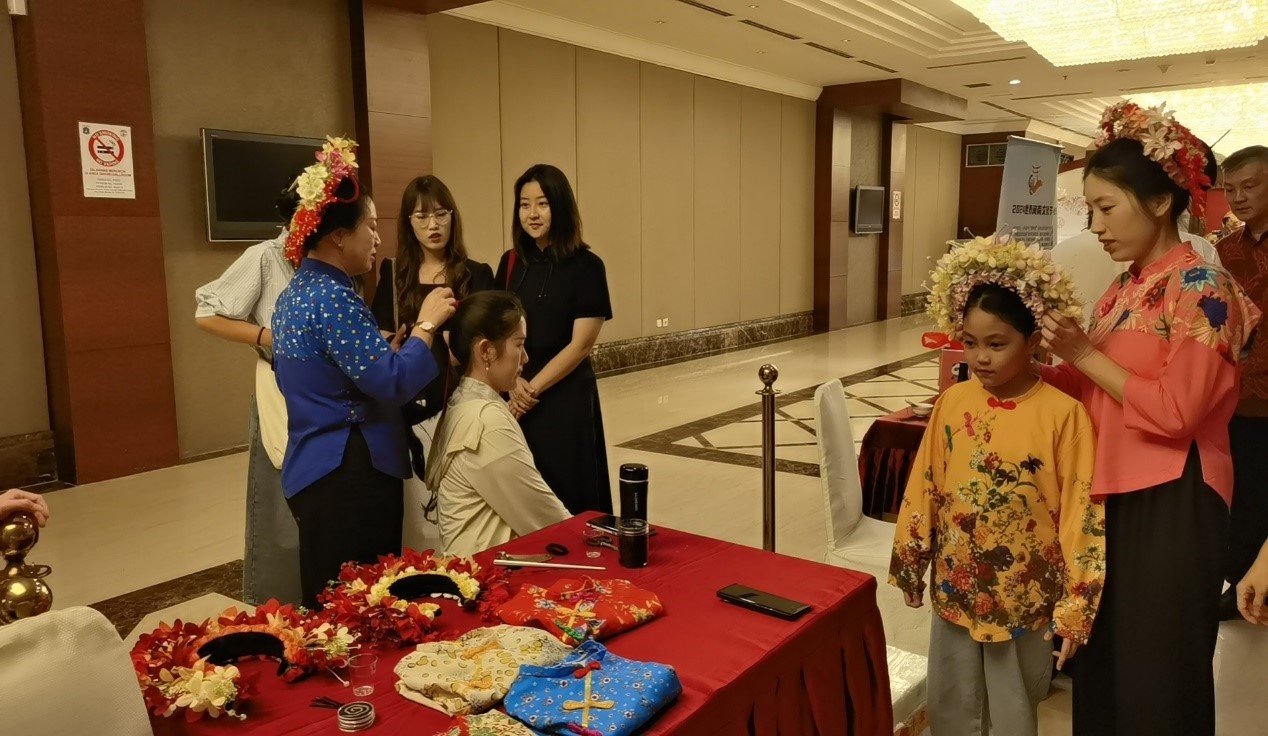 阿拉扎大學(xué)孔子學(xué)院志愿者老師向傳承人學(xué)習(xí)簪花圍。阿拉扎大學(xué)孔子學(xué)院供圖
