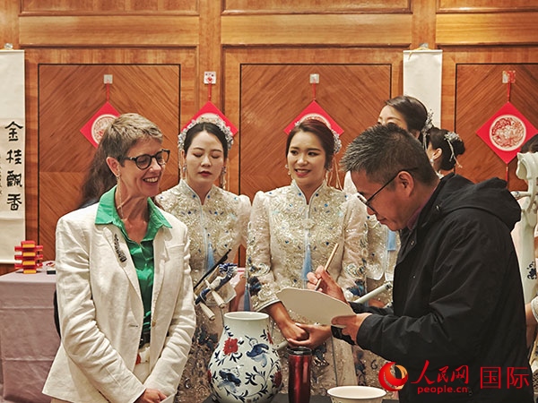 現(xiàn)場的非遺傳承人為英國觀眾展示畫技。人民網(wǎng)記者 邢雪攝