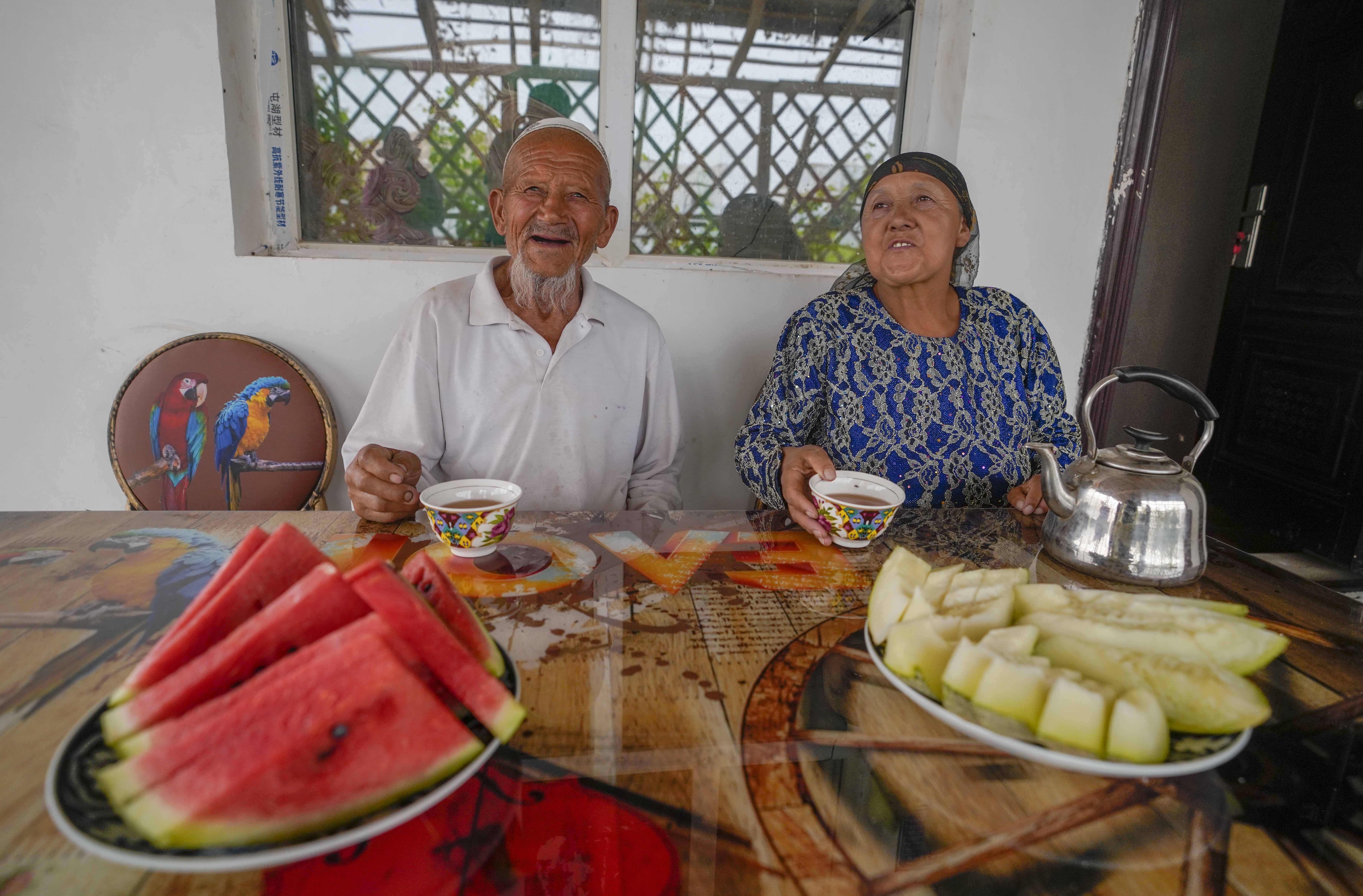 在新疆喀什地區(qū)伽師縣江巴孜鄉(xiāng)依帕克其村57號(hào)，80歲的維吾爾族老人伊米提·艾山（左）在自家庭院中（2020年6月8日攝）。