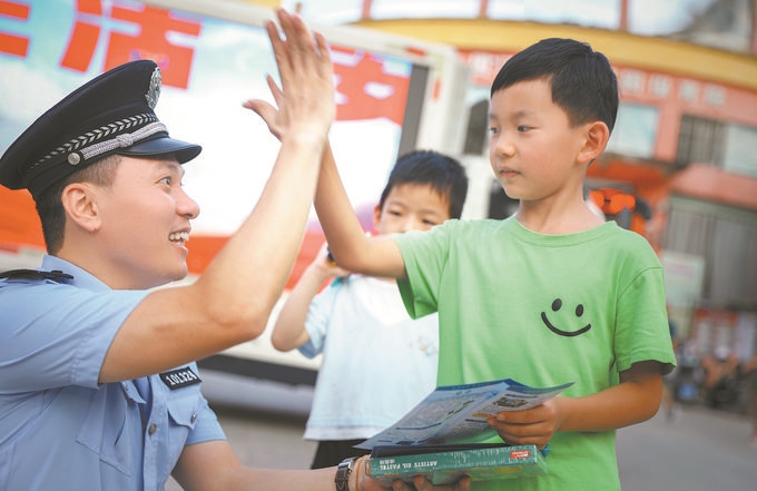 ▲7月10日，江西省吉安市公安局吉州分局組織民警深入轄區(qū)開展安全宣傳，民警向小朋友講解防溺水知識。朱文杰攝